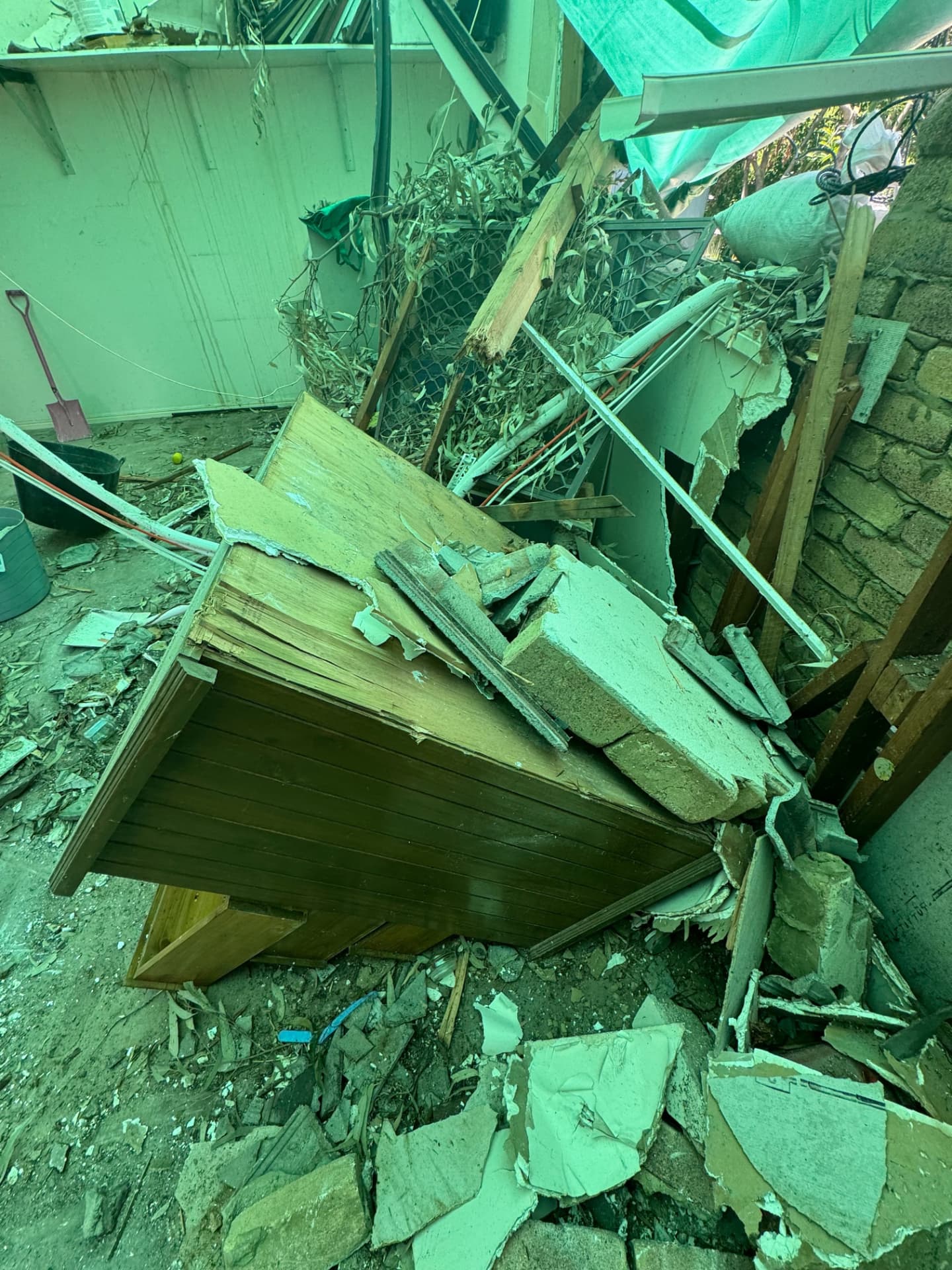 Collapsed internal wall, broken sheeting and storm debris inside a damaged Warrego property
